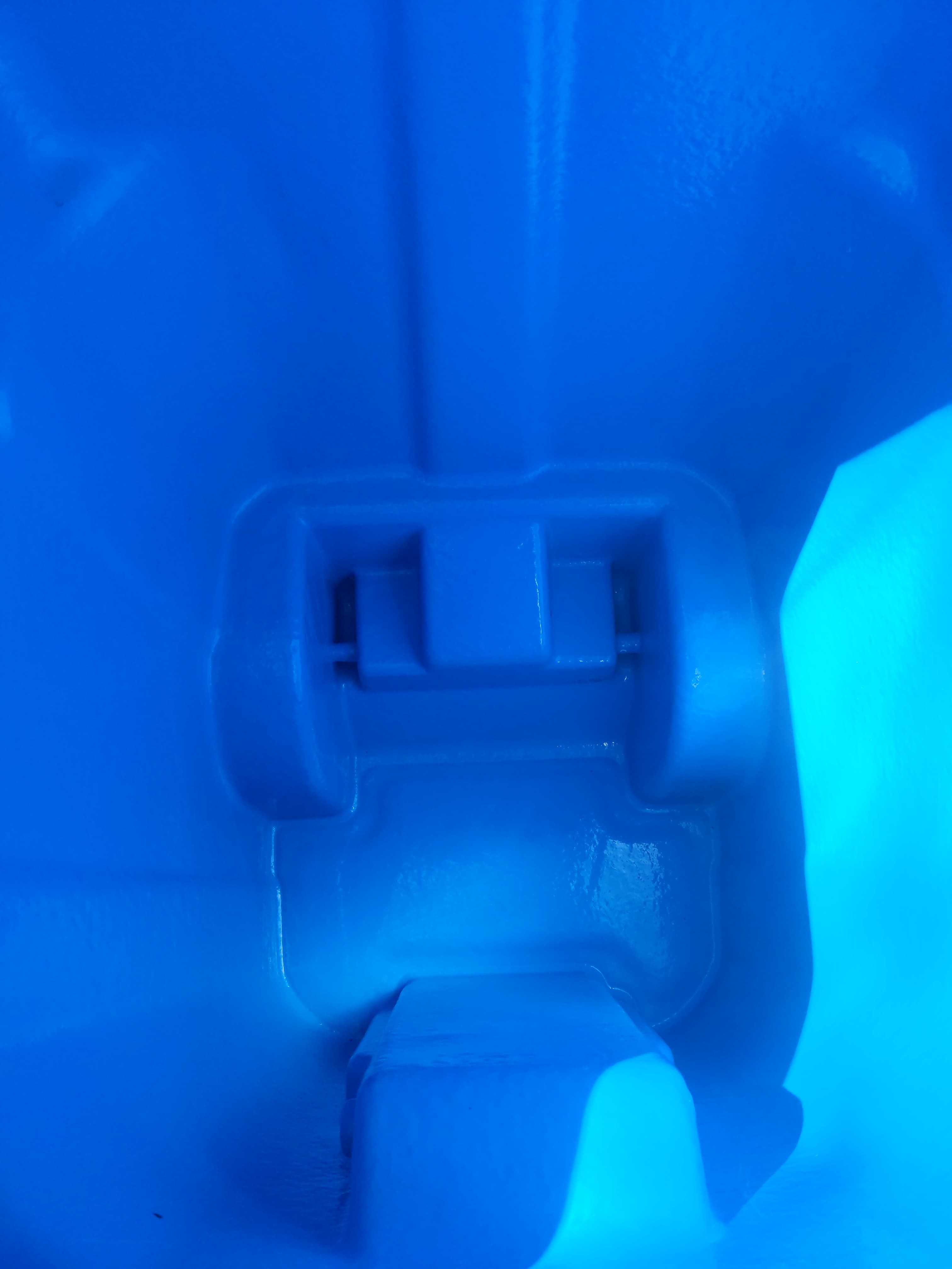 Bright blue interior of a molded plastic bin with structural indentations at the bottom.